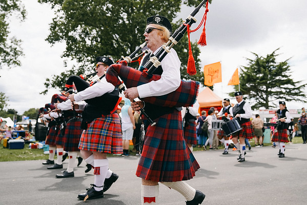 Pipe band in tartan kilts marching at the Kumeū Show