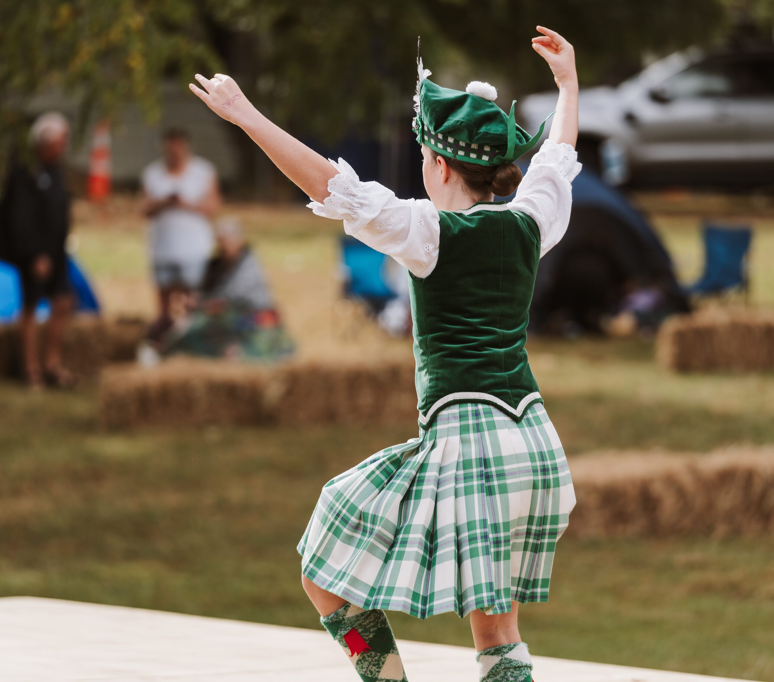 Highland dancer in tartan performing on stage