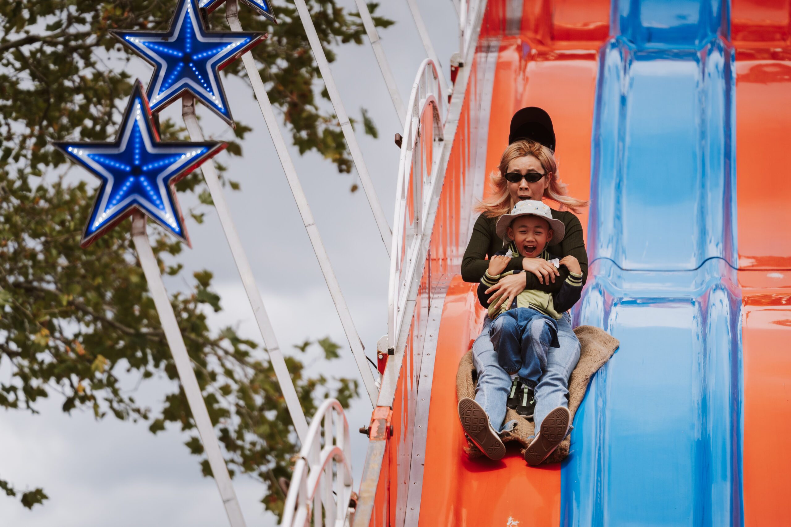 Parent and child sliding down a giant inflatable slide