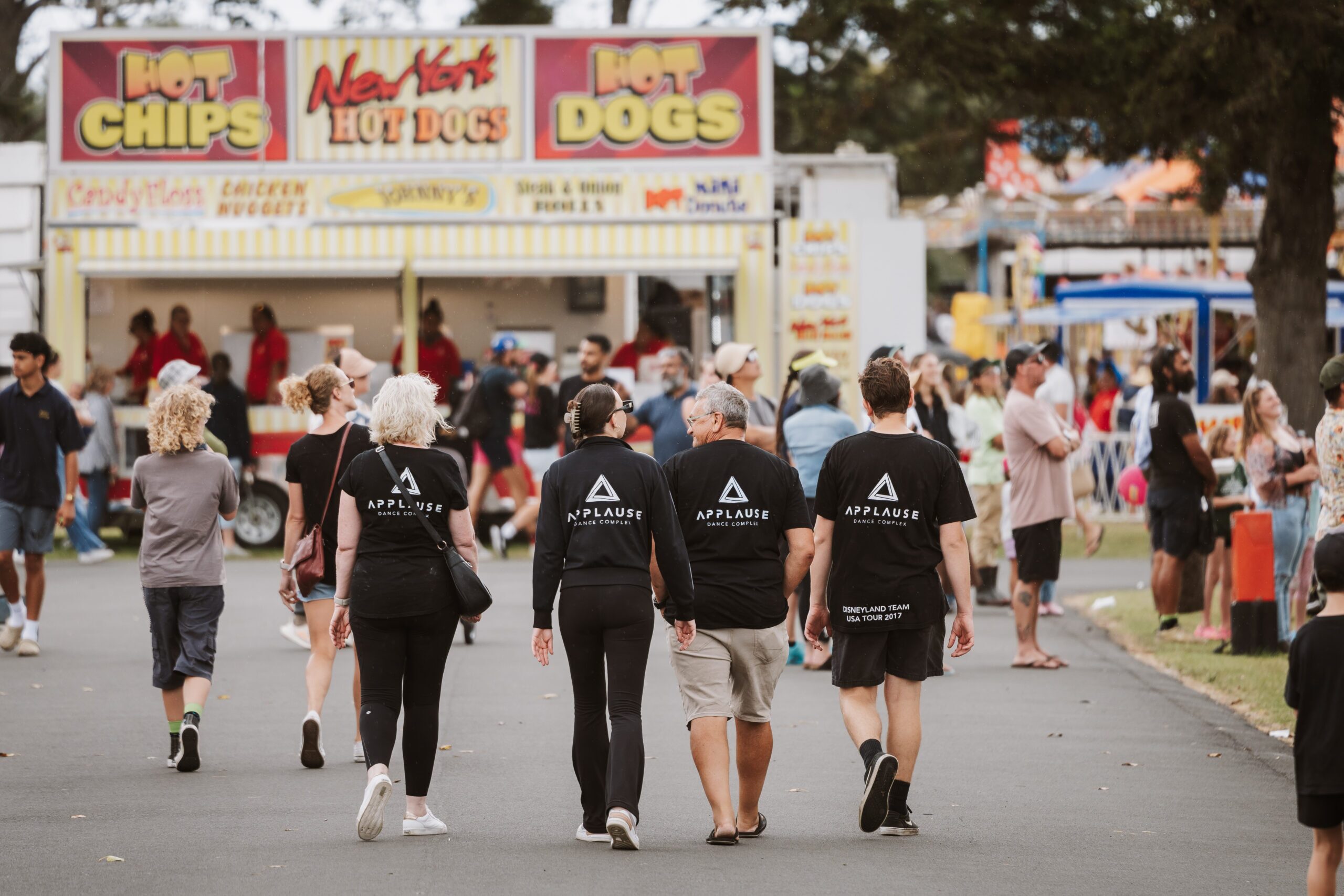 Visitors walking past food trucks selling hot chips and hot dogs